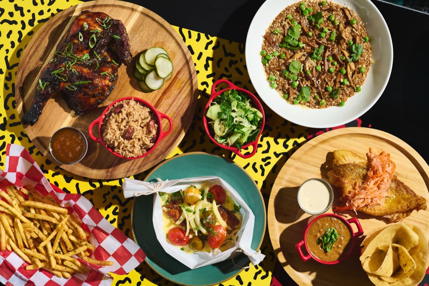 A table of Miss Lily’s dishes: jerk chicken, rice and peas, plantain and fries