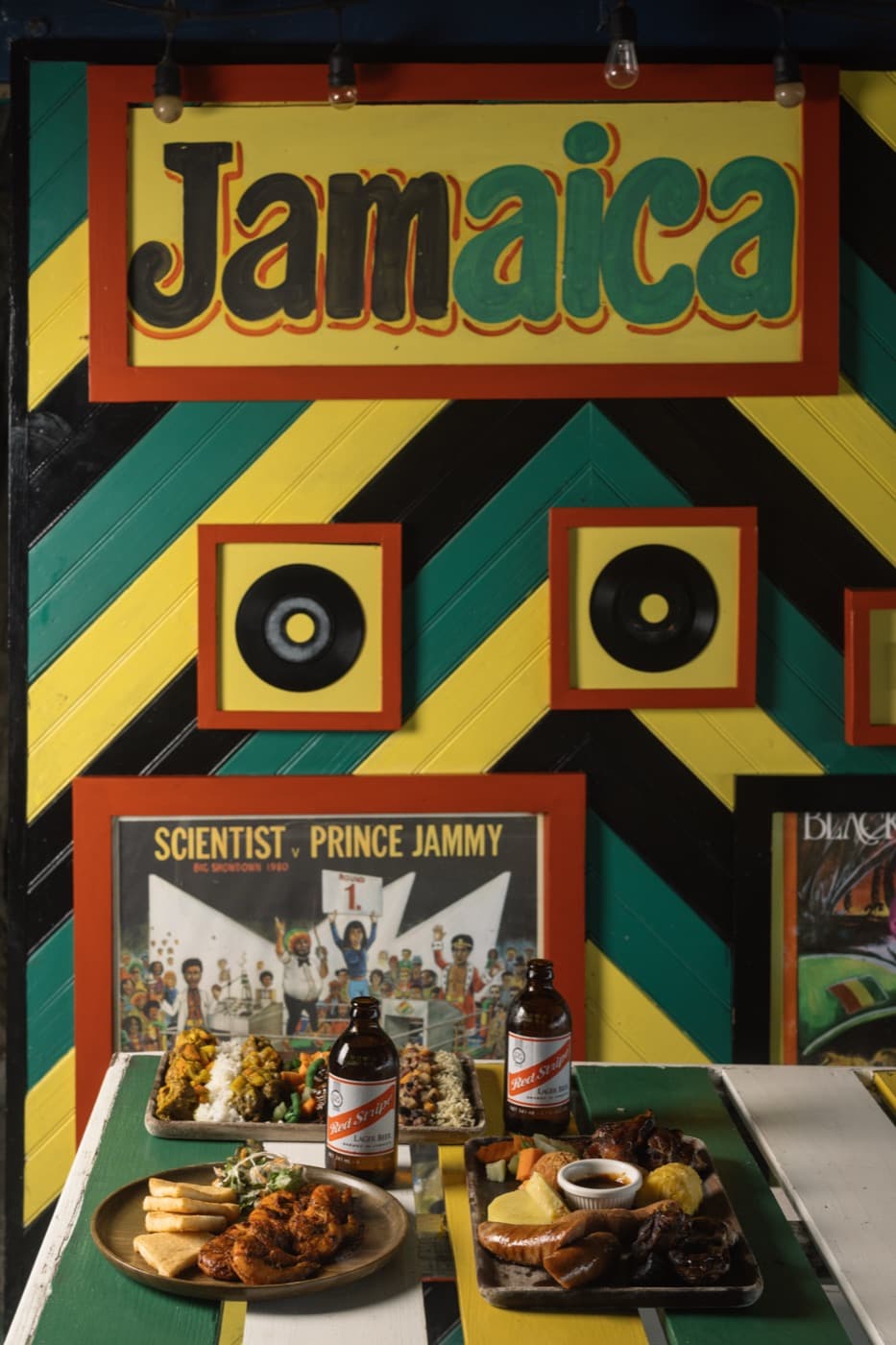 Plates on a table at Miss Lily’s, under the Jamaica mural