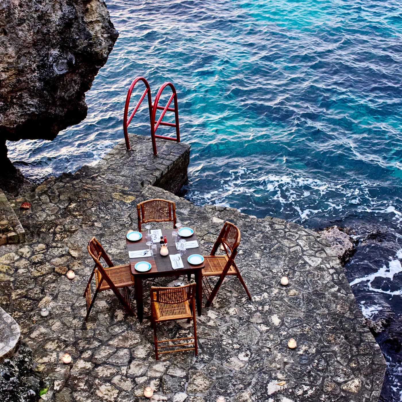 A table set on the rocks above the sea at Rockhouse